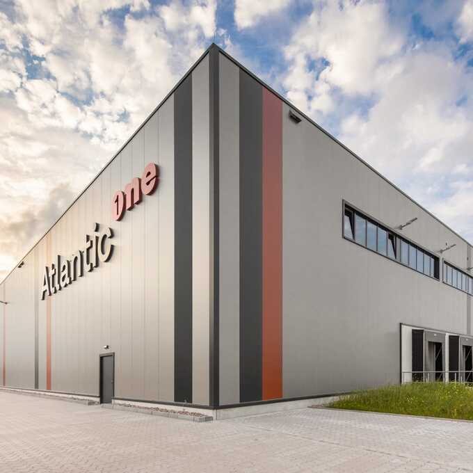 Foto der Halle "Atlantic one". Abgebildet ist eine große Gewerbehalle mit Fenstern im oberen Bereich und diversen Verlademöglichkeiten für LKW. Auf der linken Seite des Gebäudes befindet sich der Schriftzug "Atlantic one".